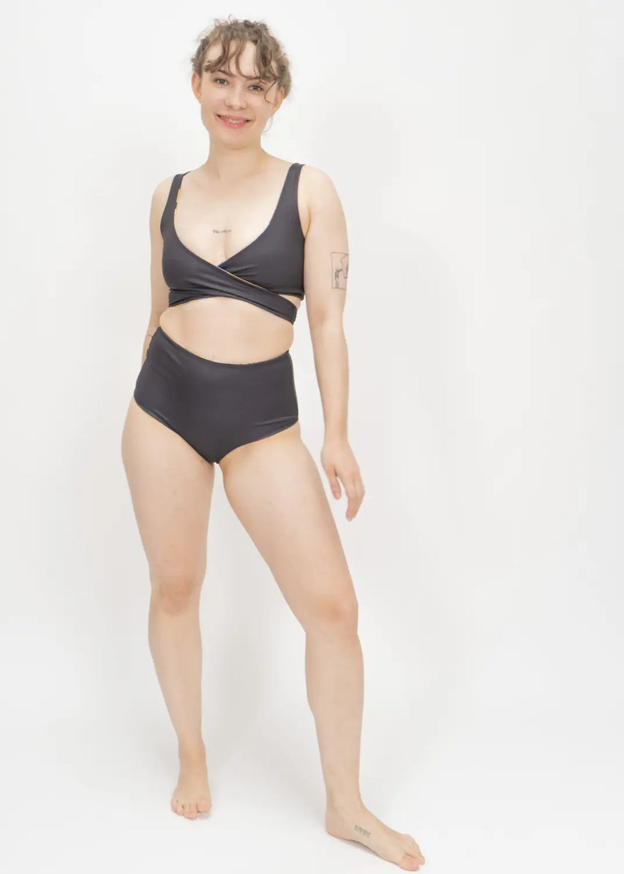 Black two-piece swimsuit with high-waisted bottoms and wrap-style top.